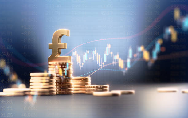 Pound Symbol On Top Of Coin Stacks Before Blue Financial Graph Pound symbol on top of coin stacks before blue financial graph. Horizontal composition with copy space. Business and finance concept. british currency stock pictures, royalty-free photos & images