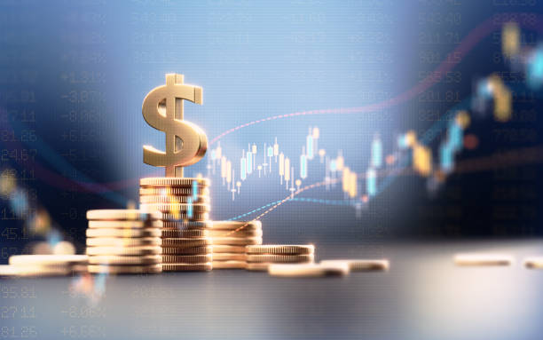 istock Dollar Sign On Top Of Coin Stacks Before Blue Financial Graph 1504303841