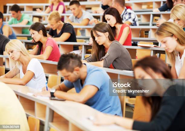 Foto de Grande Grupo De Alunos Por Escrito e mais fotos de stock de Sala de aula de universidade - Sala de aula de universidade, Universidade, Anfiteatro