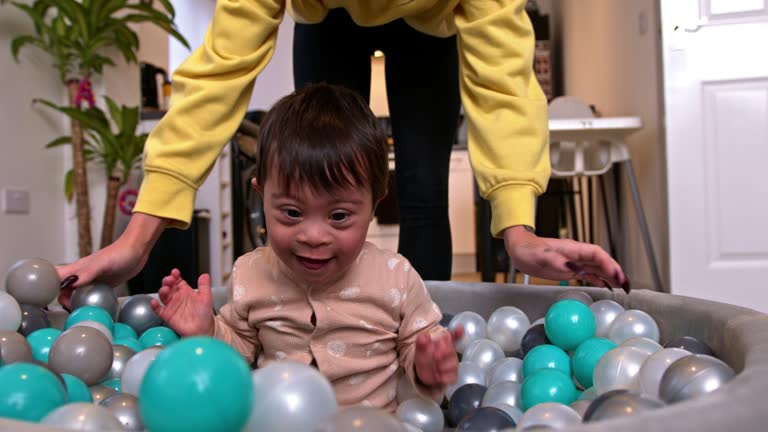 Boy Playing in the Ball Pit with Mother