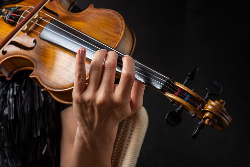 A person playing the violin showing hands holding the bow