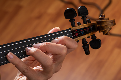 A person playing the violin showing hands holding the bow