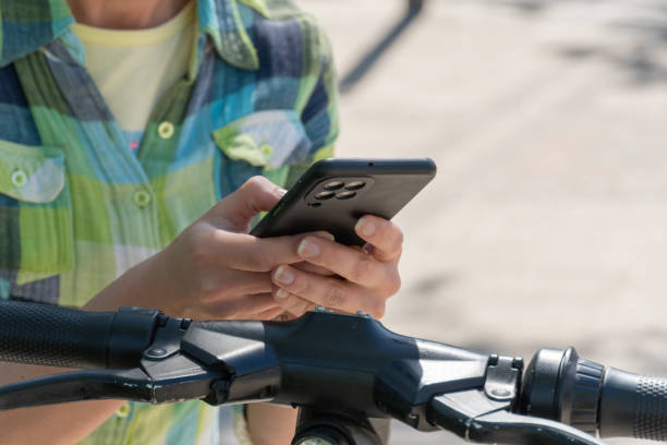 istock Woman with mobile phone scans QR code for electric scooter rental. 1504327914