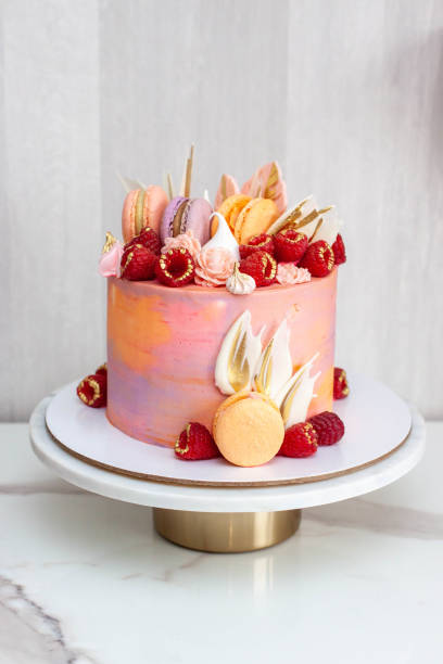 istock Pink cake decorated with fresh raspberries, chocolate petals, macaroons and meringues 1504332459
