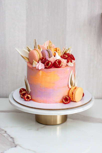 istock Pink cake decorated with fresh raspberries, chocolate petals, macaroons and meringues 1504332465