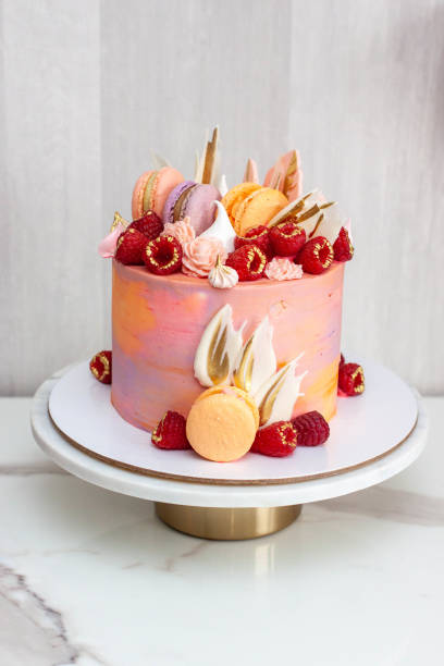istock Pink cake decorated with fresh raspberries, chocolate petals, macaroons and meringues 1504332468