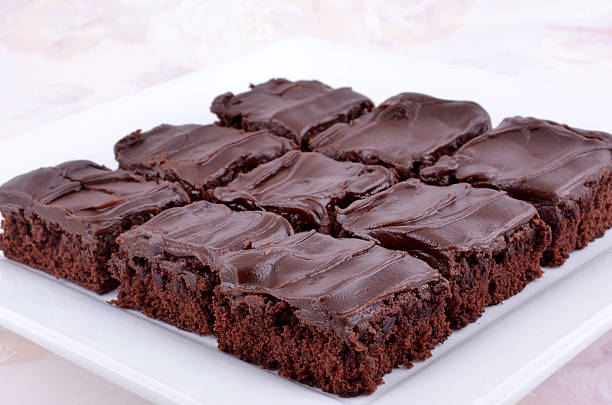 Chocolate brownies Chocolate brownies on square white plate icing stock pictures, royalty-free photos & images