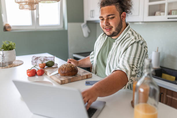 istock Young adult using a laptop for recipe ideas in a kitchen 1504348494
