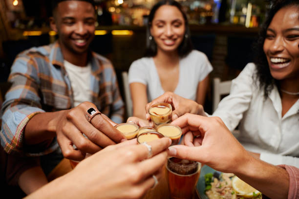jovem grupo multirracial de amigos em roupas casuais fazendo brinde comemorativo com bebidas em restaurante - table top shot - fotografias e filmes do acervo