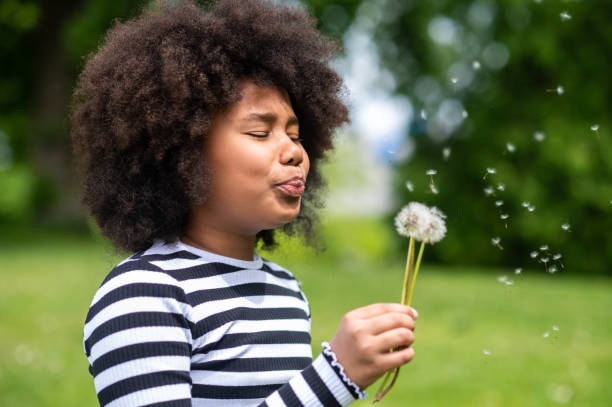 istock Curly-haired kid blowing on a dandelion 1504355847