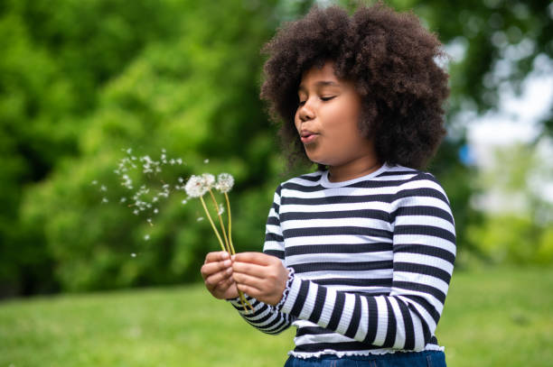 istock Curly-haired kid blowing on a dandelion 1504355858
