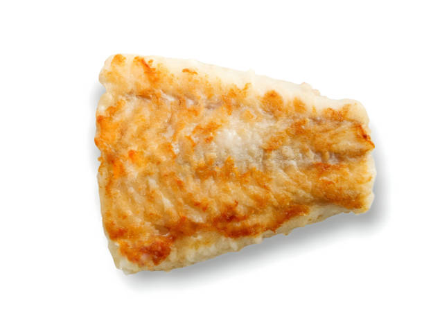 istock Pan-seared golden-brown haddock isolated on white background. Cooking at home, promoting a healthy self cooking theme. 1504376946