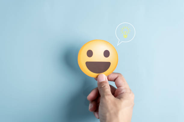 istock Hand holding smile face emoticon paper cut with light bulb smart idea, creativity and solution concept. 1504387937