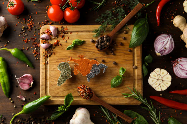 Herbs and condiments on black stone background. Top view with copy space.