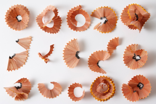 Overhead shot of pencil shavings collection isolated on white background with soft shadow.