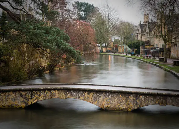 Long exposure image of the river running through  Bourton-on-the-Water in The Cotswolds in winter.