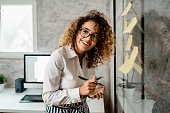 Young beautiful business woman taking notes on a sticking paper  in the office