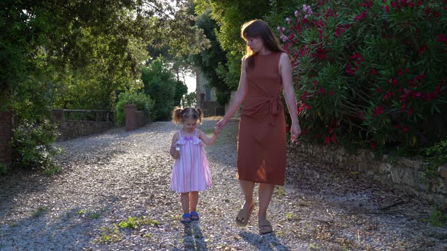 Mother and daughter walking in the garden