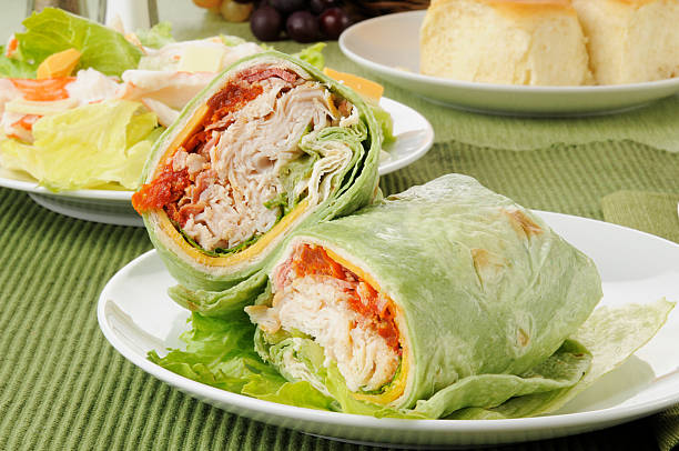 Cooking chicken roll. Tortilla wrap with fried chicken meat and vegetables, close up. Shawarma tomato, cucumber, onion, lettuce and chicken meat. Fast food. Junk food. Eating. Food. Delicious