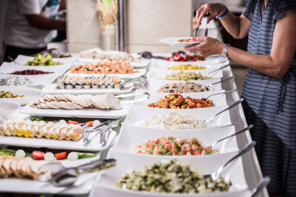 Woman  selfserving on her plate at a banquet in hotel restaurant
