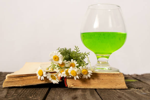 istock glass with green drink open book and chamomiles on a wooden table 1504503923