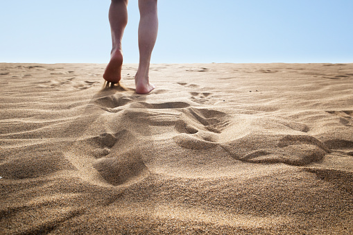 A man walking on the sand dunes of Mas Palomas, Gran Canaria of the Canary Islands, Spain