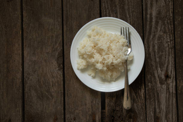 istock white plate with boiled rice on an old wooden board as a background 1504527446