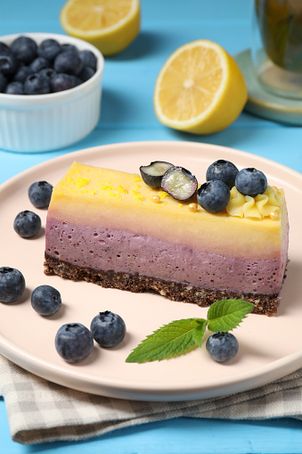 Delicious cheesecake with blueberry and mint on light blue wooden table