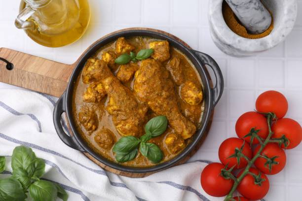 istock Delicious chicken with curry sauce and ingredients served on white tiled table, flat lay 1504546751