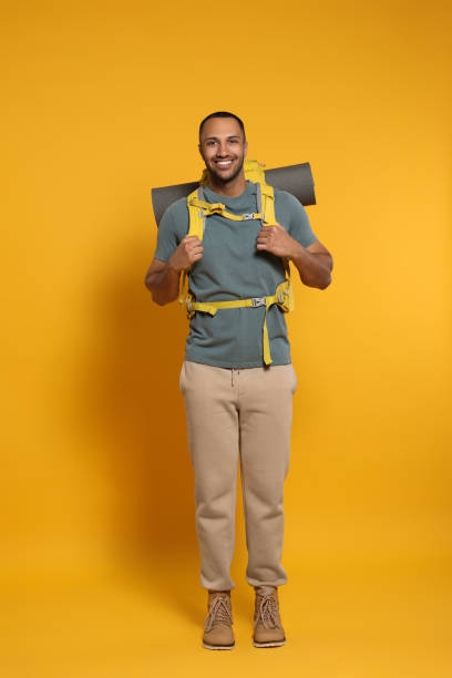 istock Happy tourist with backpack on yellow background 1504554558