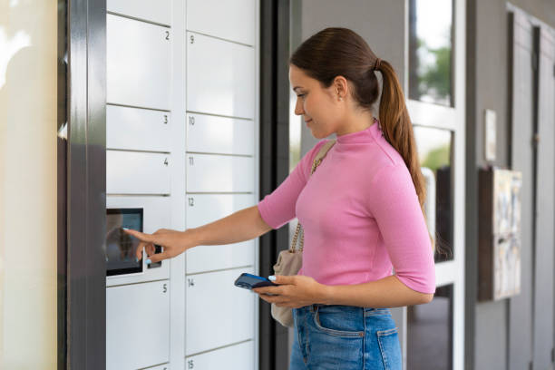 istock Young woman taking a package out of an automatic mailbox 1504583704