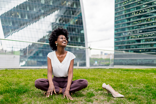 Young adult black woman relaxing outdoors during working day
