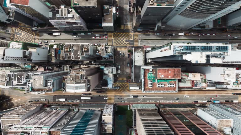 Hyperlapse timelapse of car traffic on road junction intersection in Hong Kong city downtown. Drone aerial top view fly sideway. Asian people lifestyle, Asia city life or public transportation concept