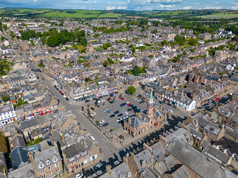 This aerial drone photo shows the town centre of Stonehaven in Aberdeenshire, Scotland. The town hall is located at a local square with some shops and a large parking lot.