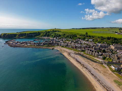 This aerial drone photo shows the harbour town of Stonehaven in Aberdeenshire, Scotland. It has a beautiful port and a beach with a turquoise water bay.