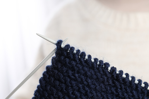 Knitting needles and knitwear, close up and selective focus