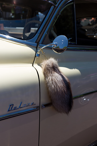 Santa Fe, NM: Close-up of a vintage lowrider car (with a fox or raccoon tail hung on the mirror) parked on the historic Santa Fe Plaza on the annual (June) Lowrider Day.