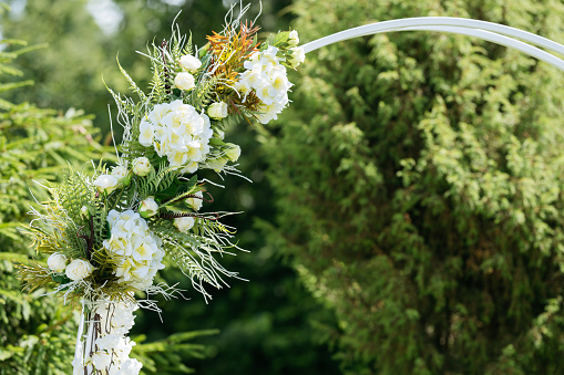Part of archway with white flowers for wedding ceremony. Space for text.