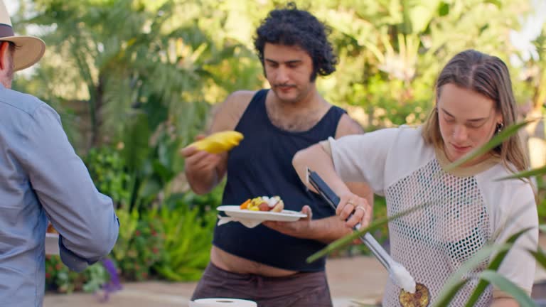 Couple Preparing Hot Dogs At a Barbecue