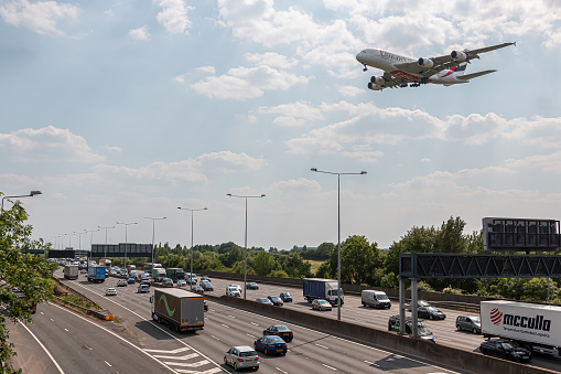 London, UK - June 14, 2023: Huge passenger plane Airubs a380 Emirates Airlines approaching to London Heathrow Airport low above busy motorway M25