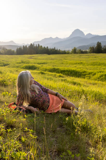 istock Senior female hiker relaxes in mountain meadow 1504682349
