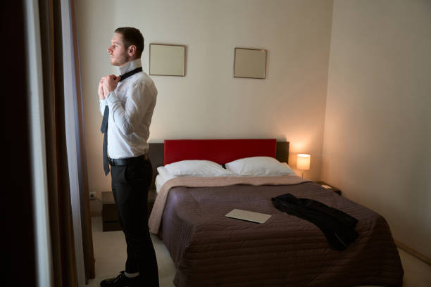 istock Thoughtful young gentleman getting dressed for business meeting in aparthotel 1504684457