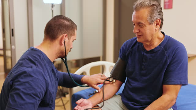 Nurse taking a senior mans blood pressure reading