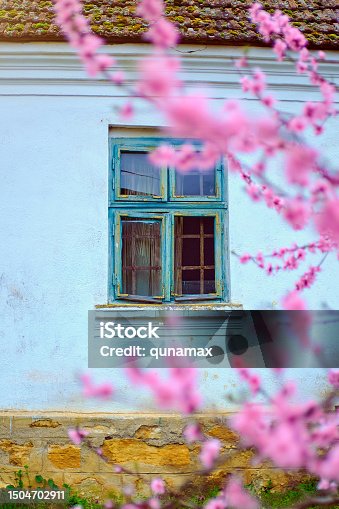 istock Traditional countryside house, wall with windows and colorful flowers 1504702911