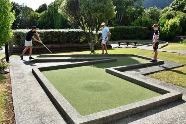 A family plays mini golf in summer.