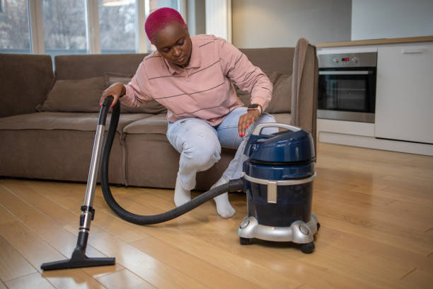 istock Woman cleaning floor with vacuum cleaner 1504758348
