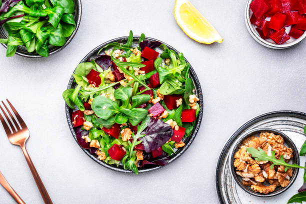 istock Beet salad with arugula, lettuce, chard and walnuts and lemon dressing, gray kitchen table, copy space. Fresh useful vegan dish for healthy eating 1504764769