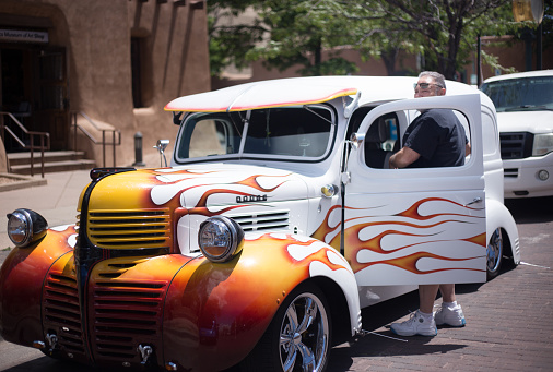Santa Fe, NM: A man getting out of his lowrider vehicle on the historic Santa Fe Plaza on the annual (June) Lowrider Day.