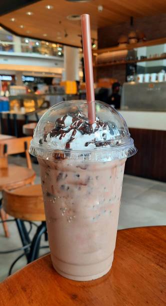 istock Chocolate ice in a plastic cup on a wooden table with bokeh background. Cold drink in hot weather. Relaxed in the cafe while enjoying a drink 1504837369