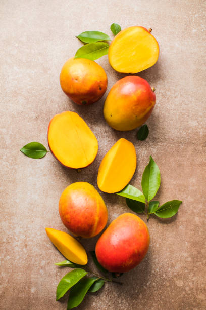 istock Mango background design concept. Top view of  fresh mango fruit pattern with leaves on  table. 1504841205